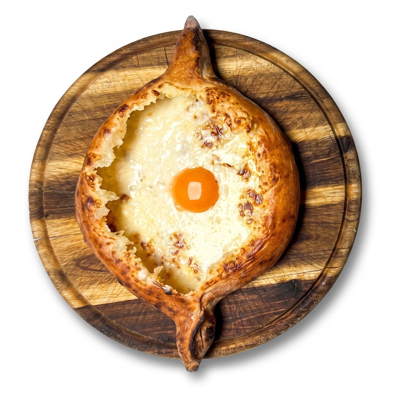 Khatchapuri Adjaruli Tsom Gamotslili — boat-shaped khatchapuri with smoked cheese and egg